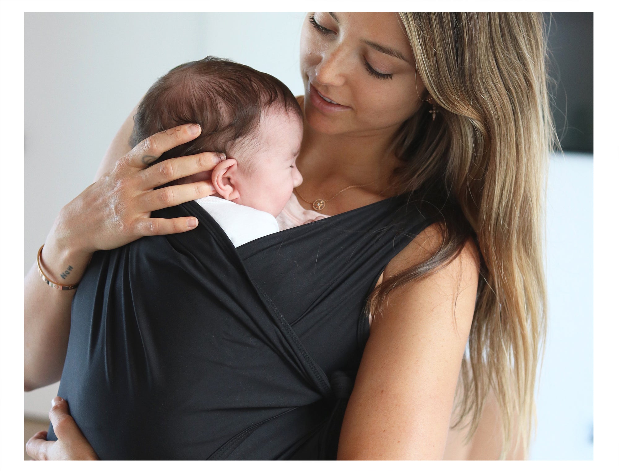 Mother holding baby with Nesting Days Carrier